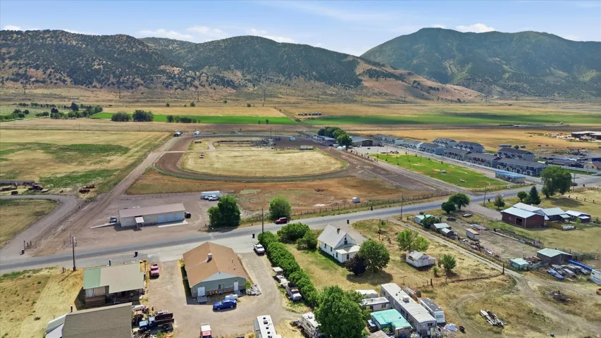 Expansive rural landscape featuring a dirt track, surrounding fields, and distant mountains