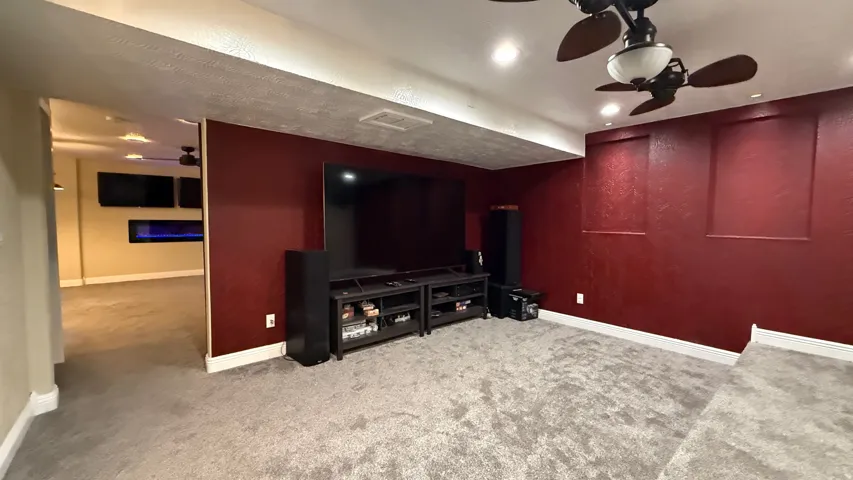 Recessed lighting, ceiling fan with light fixture, textured walls, wall-mounted electric fireplace, and wall-mounted televisions