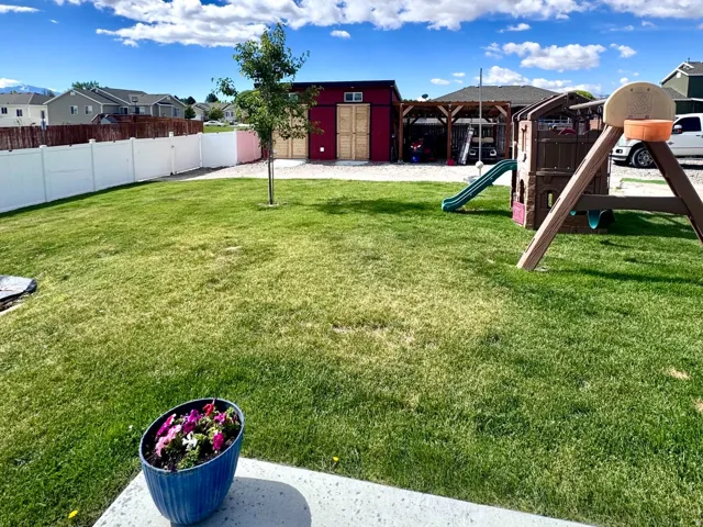 Expansive green lawn with a white privacy fence