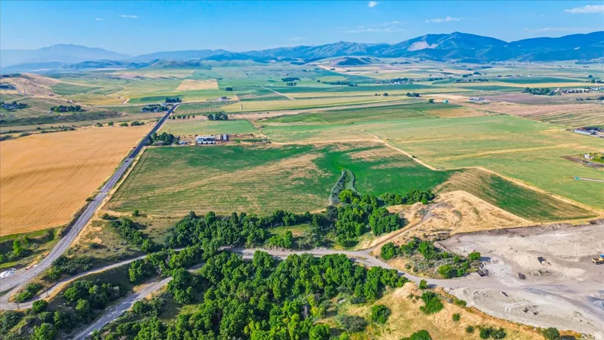 Expansive parcel featuring varied terrain including wooded areas, open fields, and mountain backdrops