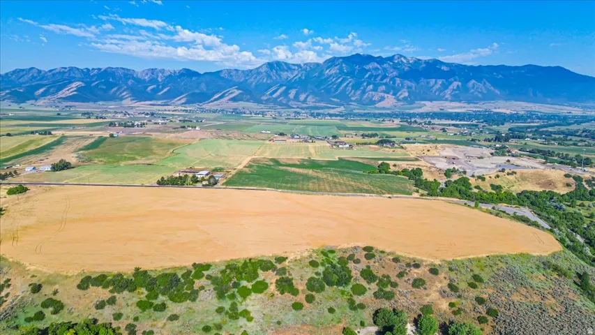 Expansive fields featuring varied terrain and distant mountain ranges under a clear sky