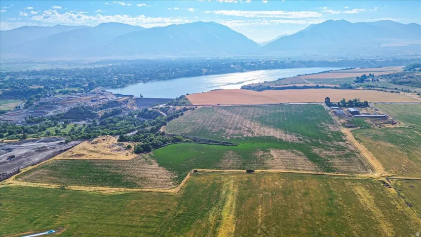 Expansive agricultural land featuring varied crop fields and distant mountainous terrain