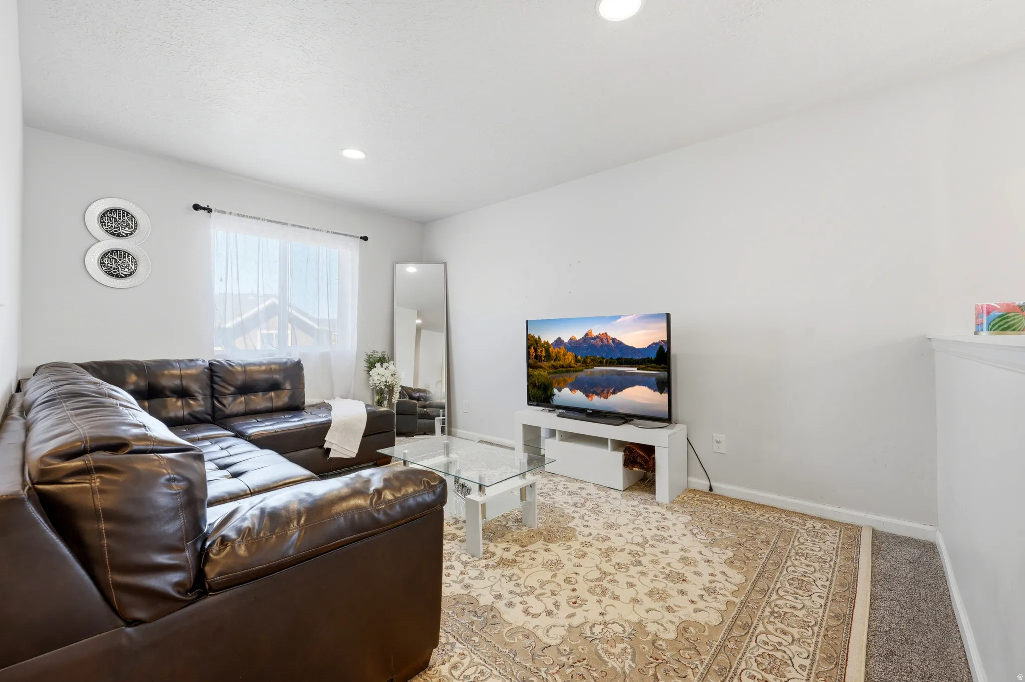 Upper level loft living area featuring recessed lighting, light-toned wall paint, and a window with sheer white coverings