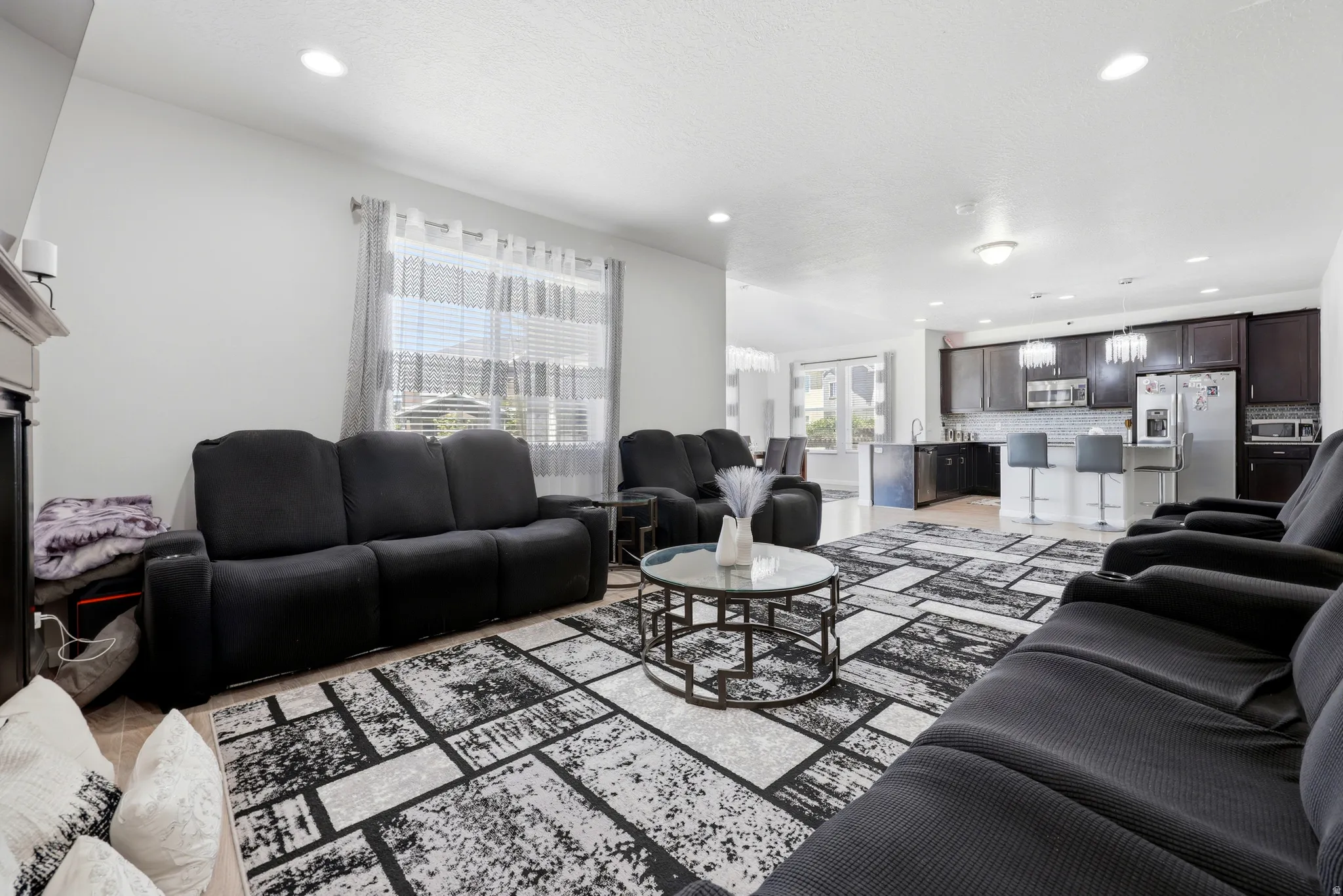 Open-concept living space featuring a fireplace, recessed lighting, and wood-finish flooring