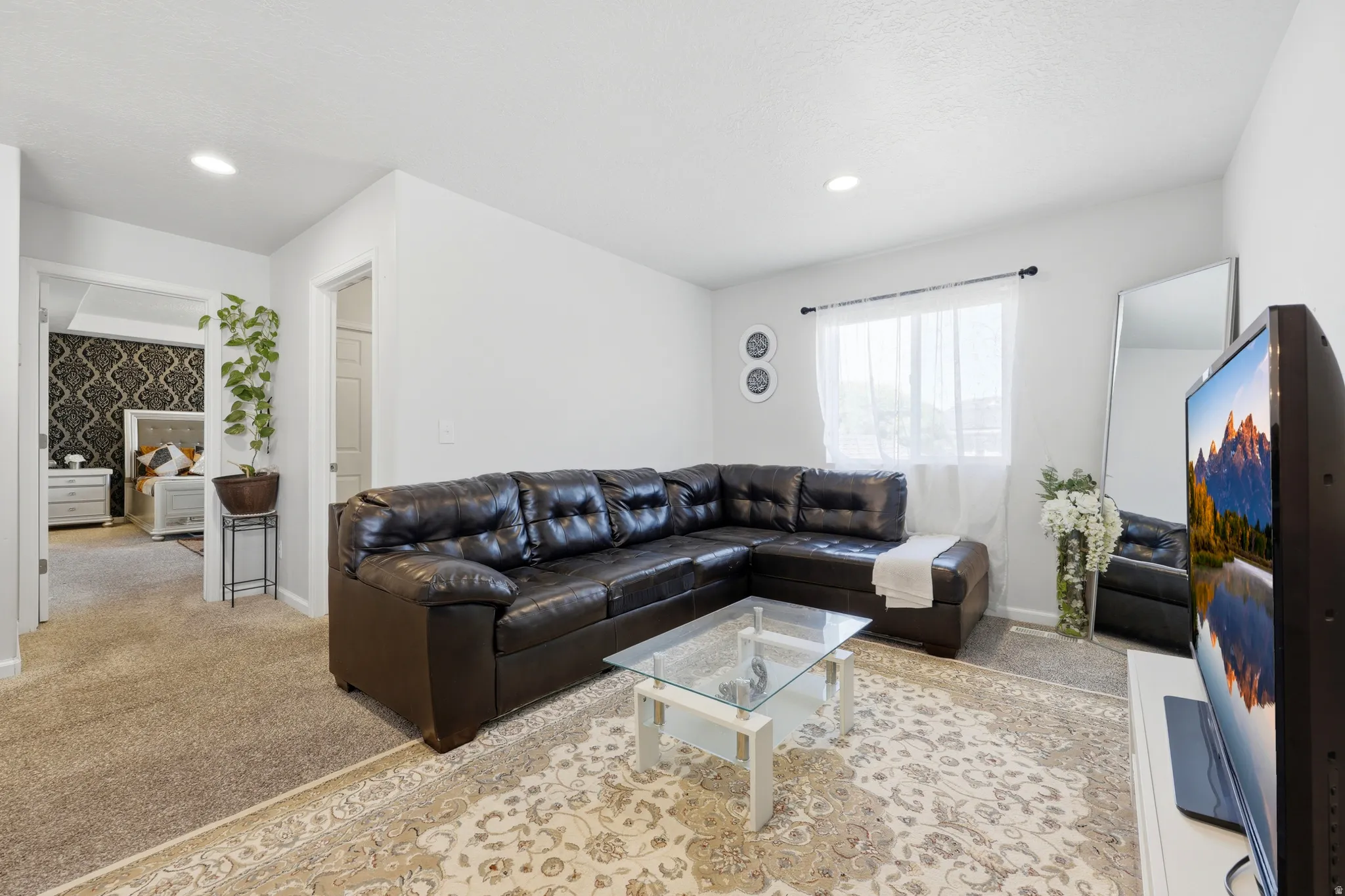 Spacious living area featuring neutral walls and recessed lighting