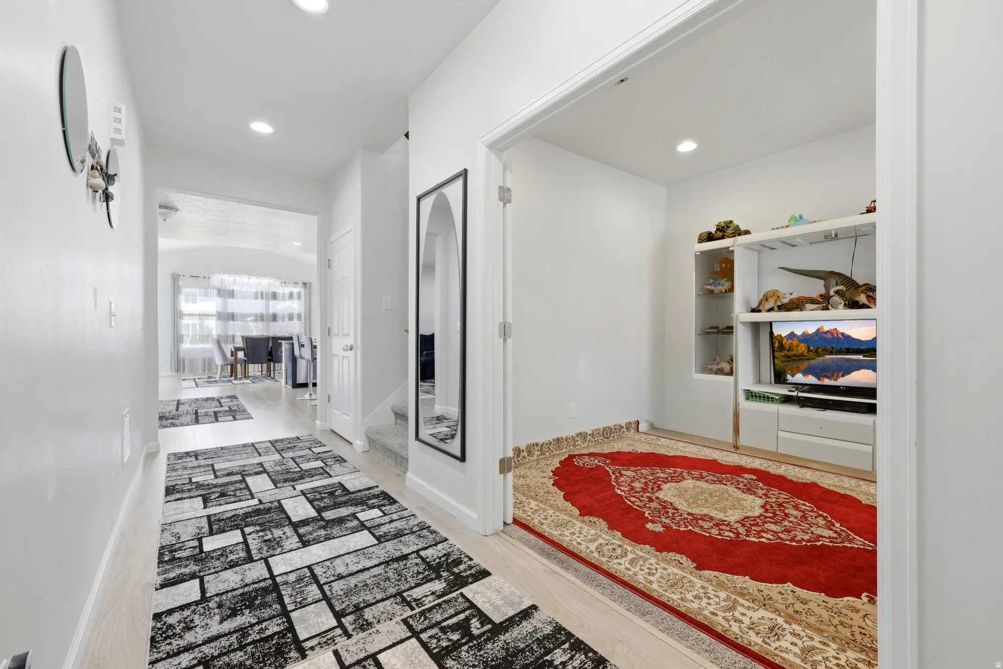 Bright interior hallway featuring light-toned flooring, recessed lighting, and white walls