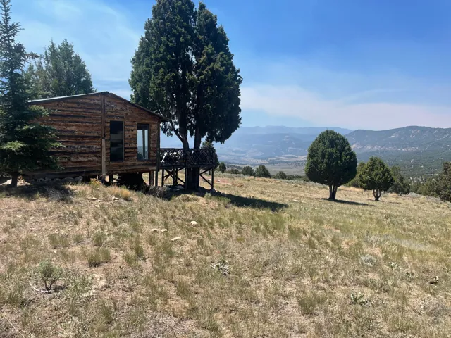 Rustic cabin structure featuring wood siding and a private elevated deck