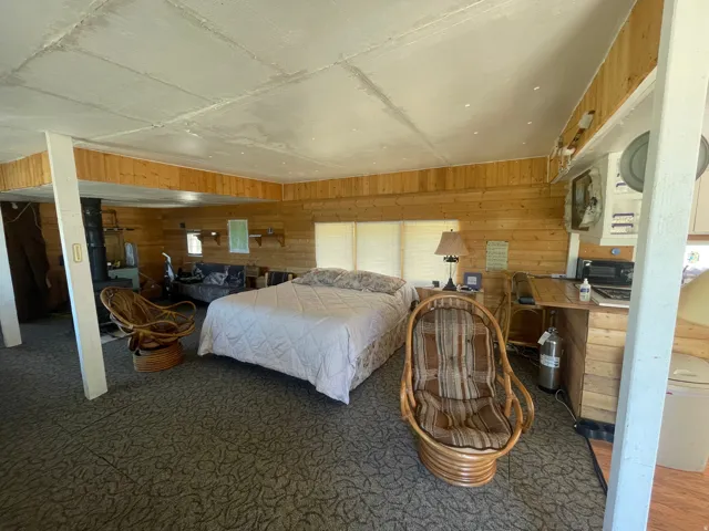 Spacious room featuring wood-finish wall paneling and a light-colored ceiling
