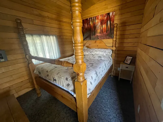 Interior room featuring wood-paneled walls and a window with sheer curtains