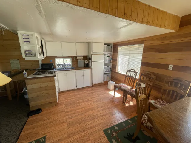 Kitchen and dining area featuring wood-finish flooring and paneled walls