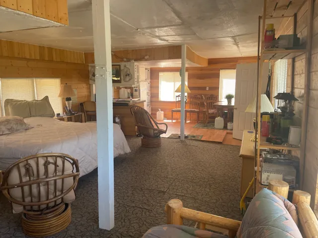 Expansive open-concept room featuring wood-paneled walls and a built-in shelving unit