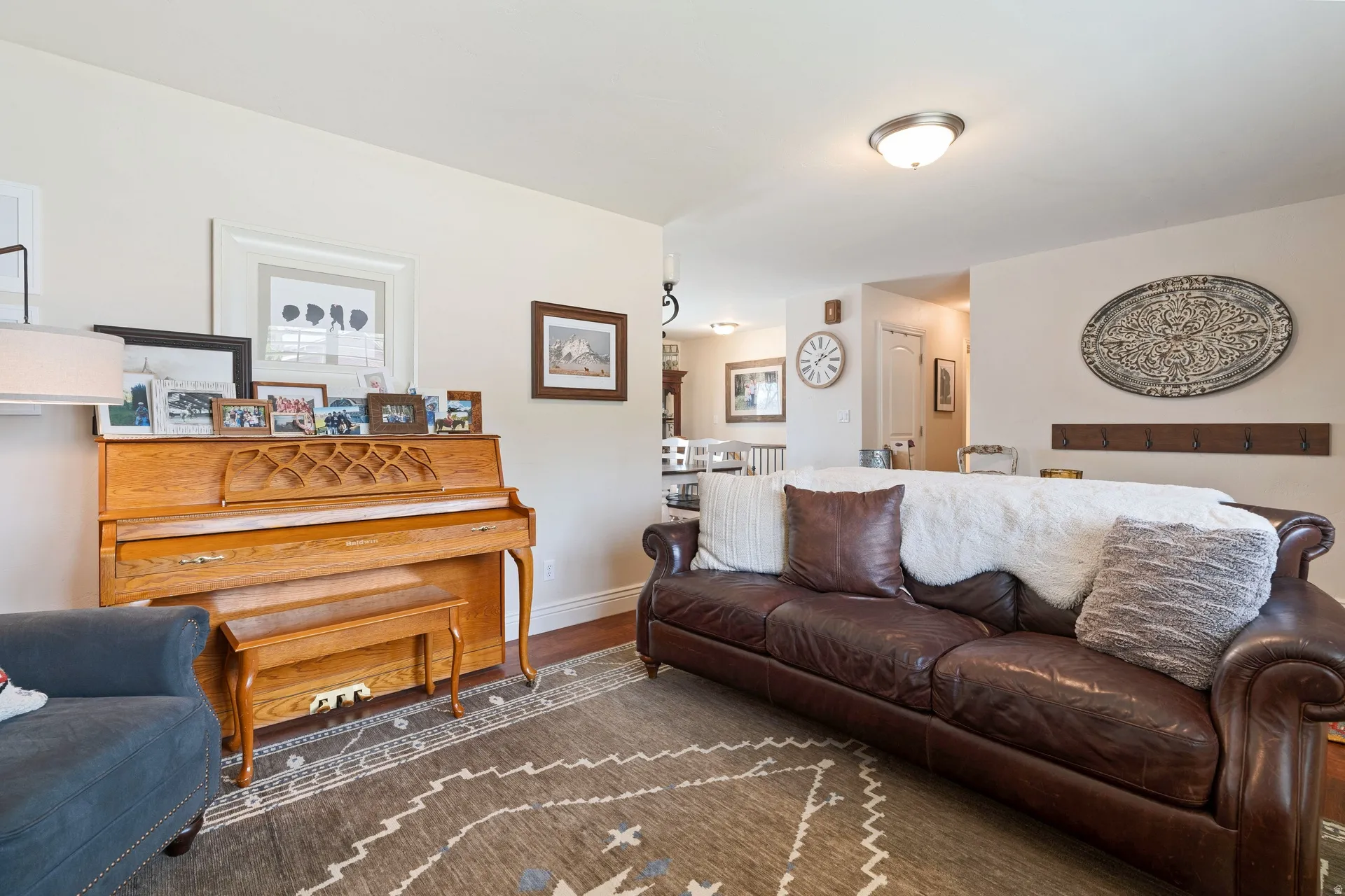 Spacious living area featuring wood-finish flooring, light-toned walls, and a ceiling-mounted light fixture