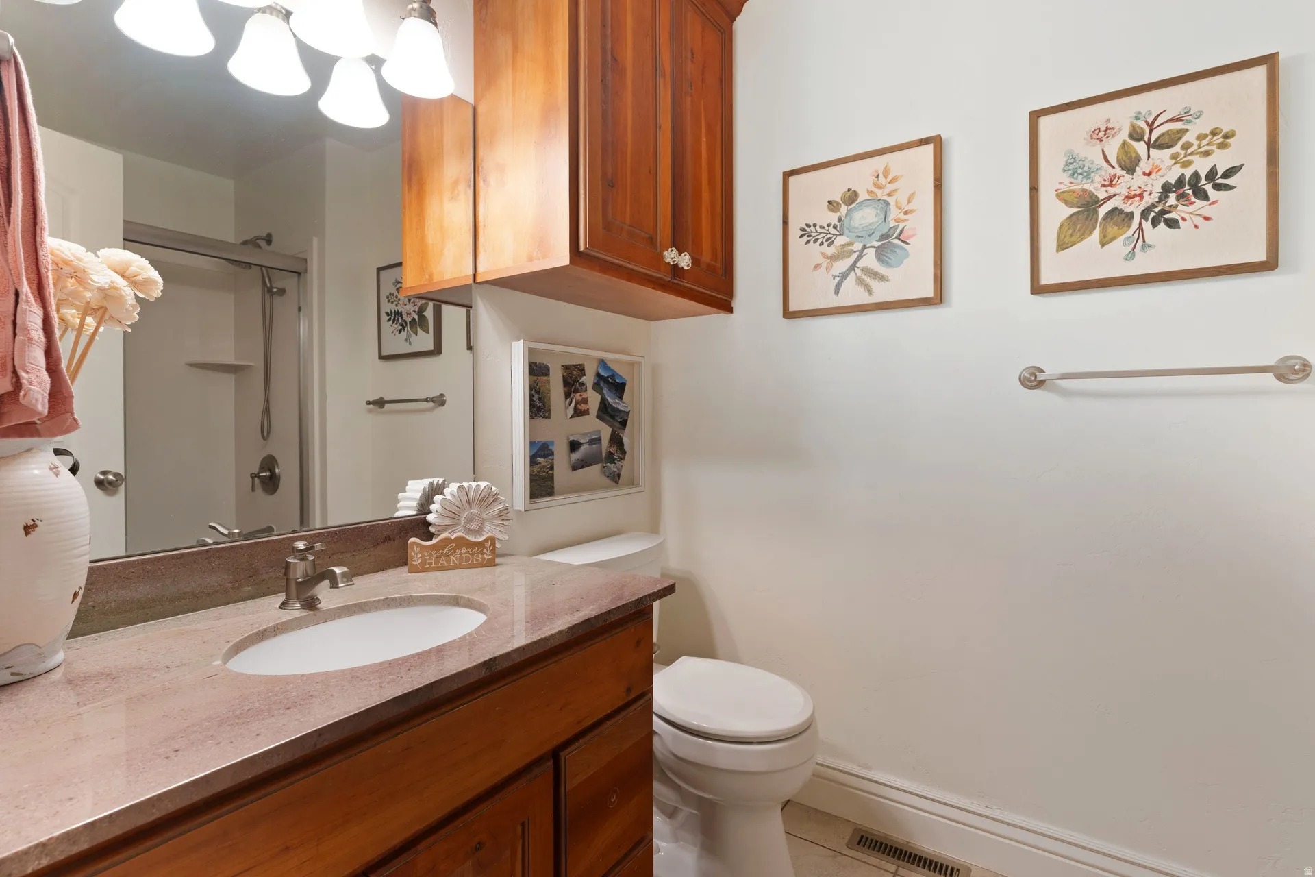 Bathroom featuring a single vanity with an integrated sink, a light-toned countertop, and wood-finish cabinetry