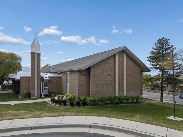 Brick exterior featuring a spire, gabled roofline, and integrated outdoor lighting
