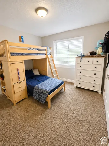 Bedroom featuring neutral wall paint, a window with horizontal blinds, and a built-in light fixture