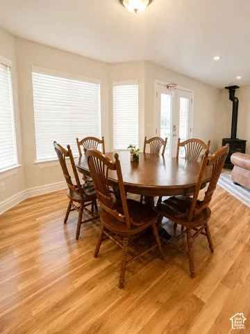Dining area featuring wood-finish flooring, a bay window with blinds, and white trim
