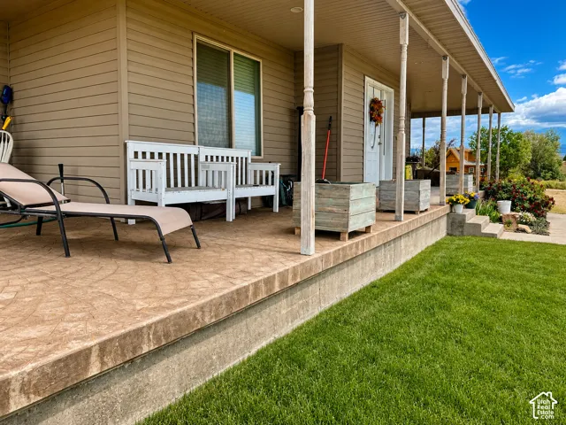 Expansive covered front porch featuring textured concrete flooring