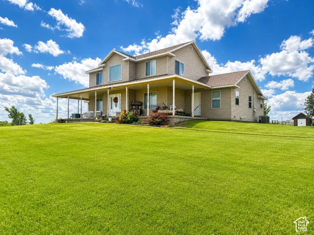 Two-story residence with beige siding and a covered wrap-around porch