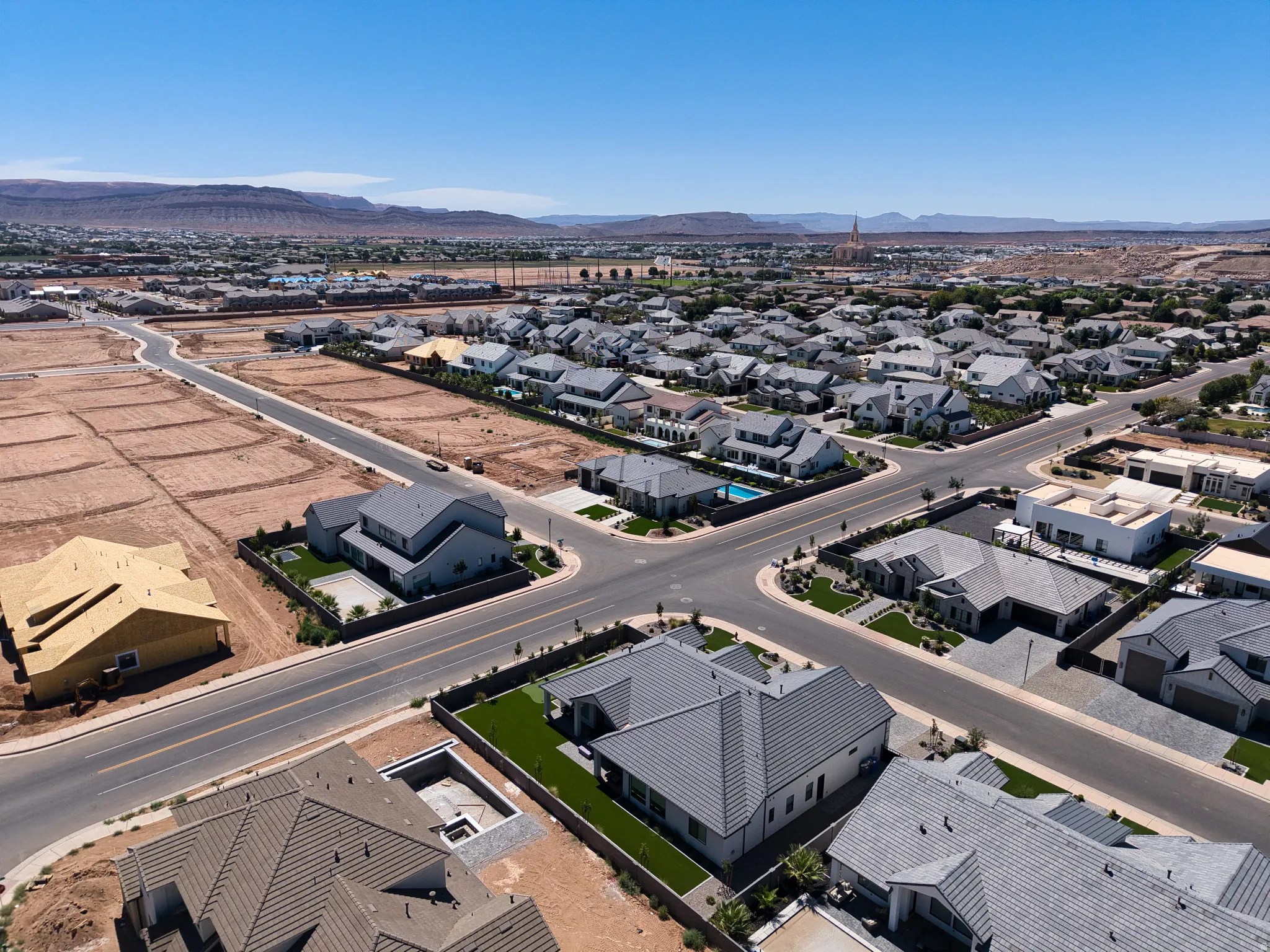 Aerial perspective showcasing a developing residential neighborhood with established homes and vacant lots