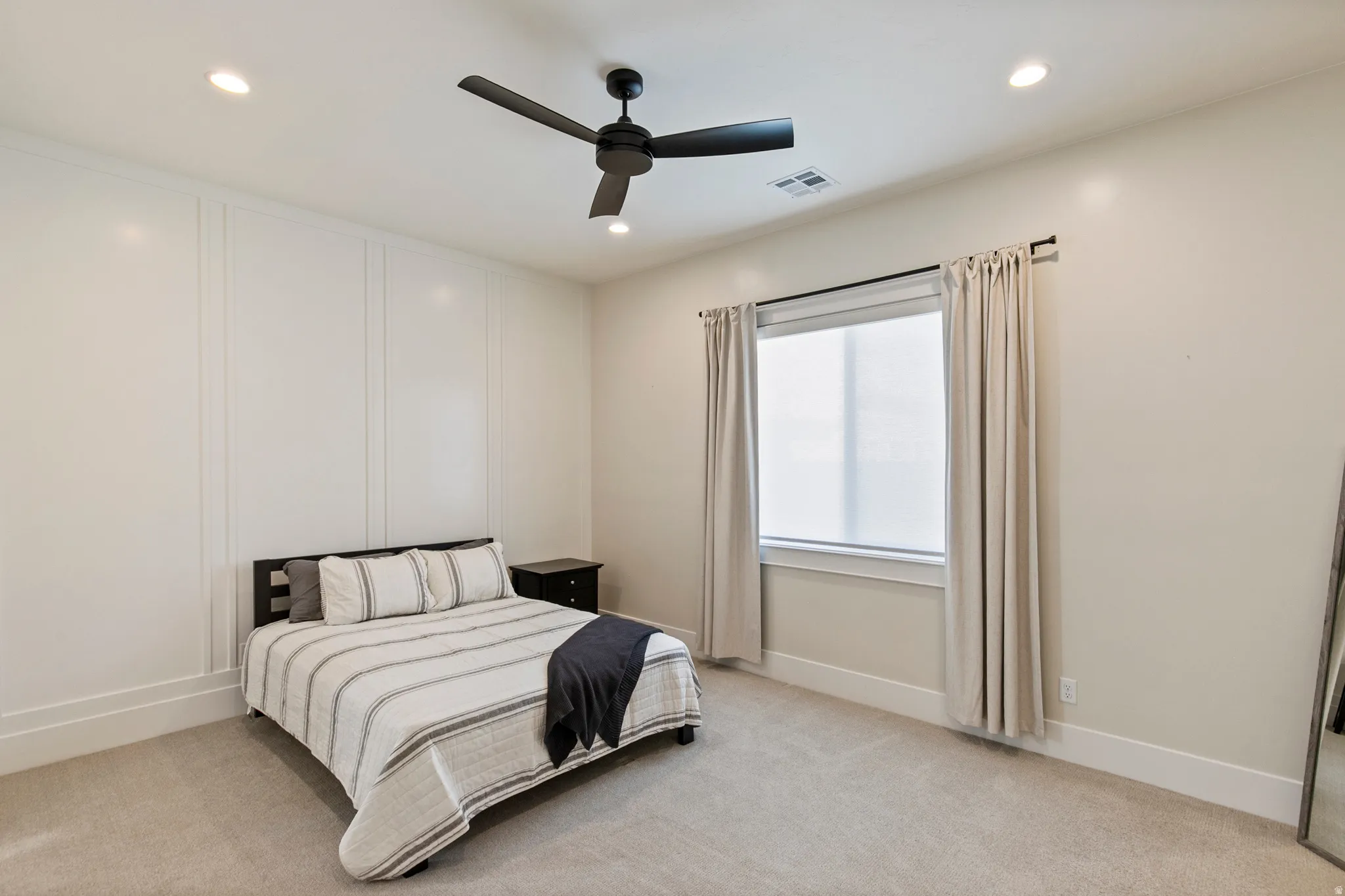 Interior room featuring a textured accent wall, recessed lighting, and a dark-toned ceiling fan
