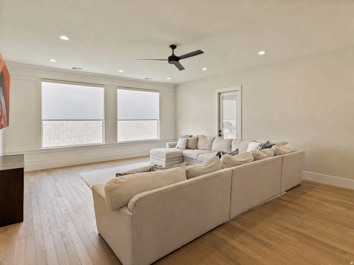 Spacious living area featuring wood-finish flooring, recessed lighting, and a modern ceiling fan