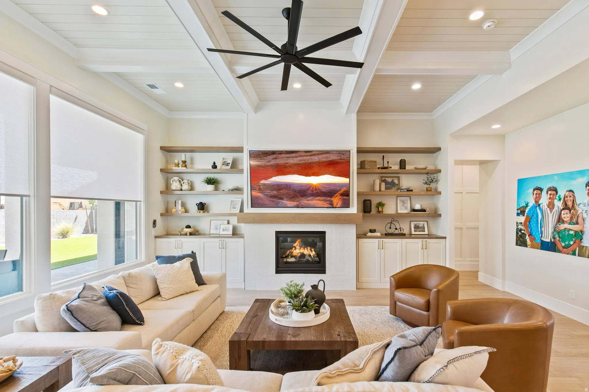 Spacious living area featuring a fireplace, built-in shelving, and a coffered ceiling with a ceiling fan