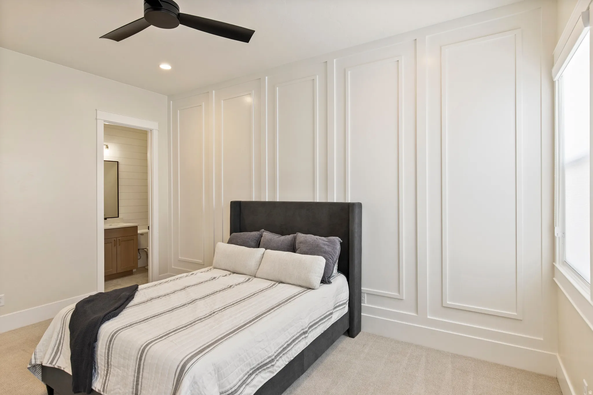 Interior space featuring wainscoting paneling, recessed lighting, and a window with white trim