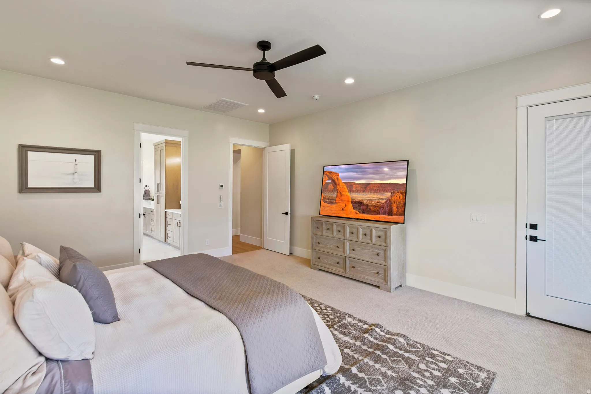 Carpeted bedroom with a matte black ceiling fan, recessed lighting, and a white paneled door