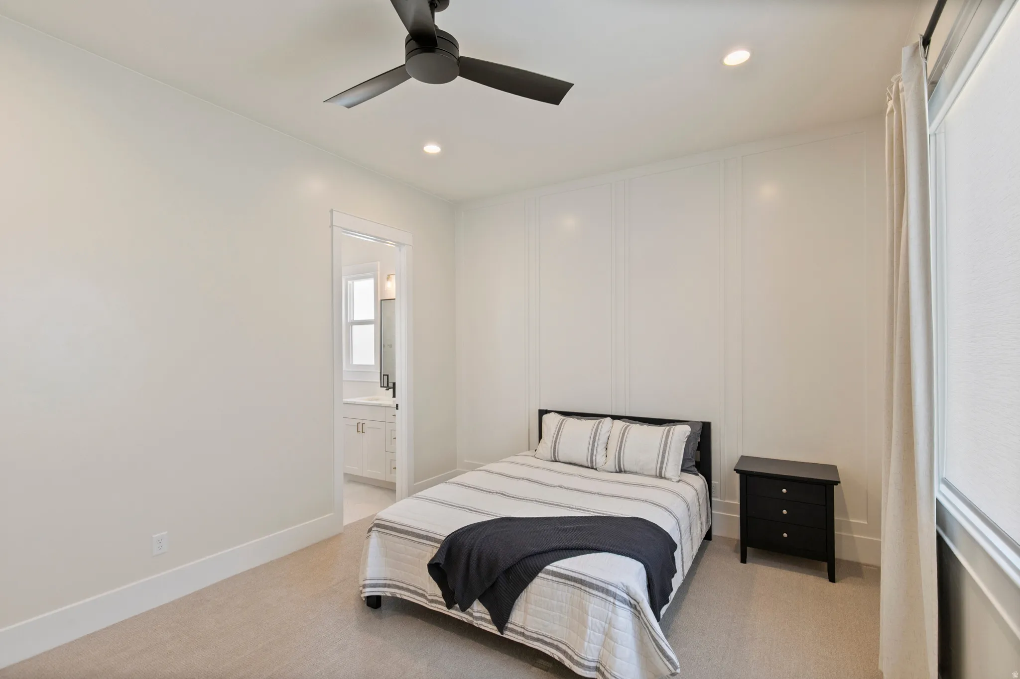 Bedroom featuring white paneled accent wall, recessed lighting, and a modern ceiling fan