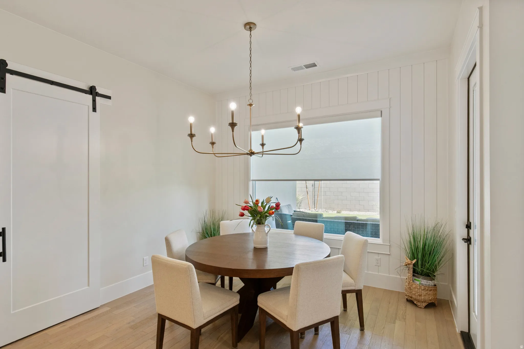 Dining area featuring light wood-finish flooring and a central chandelier