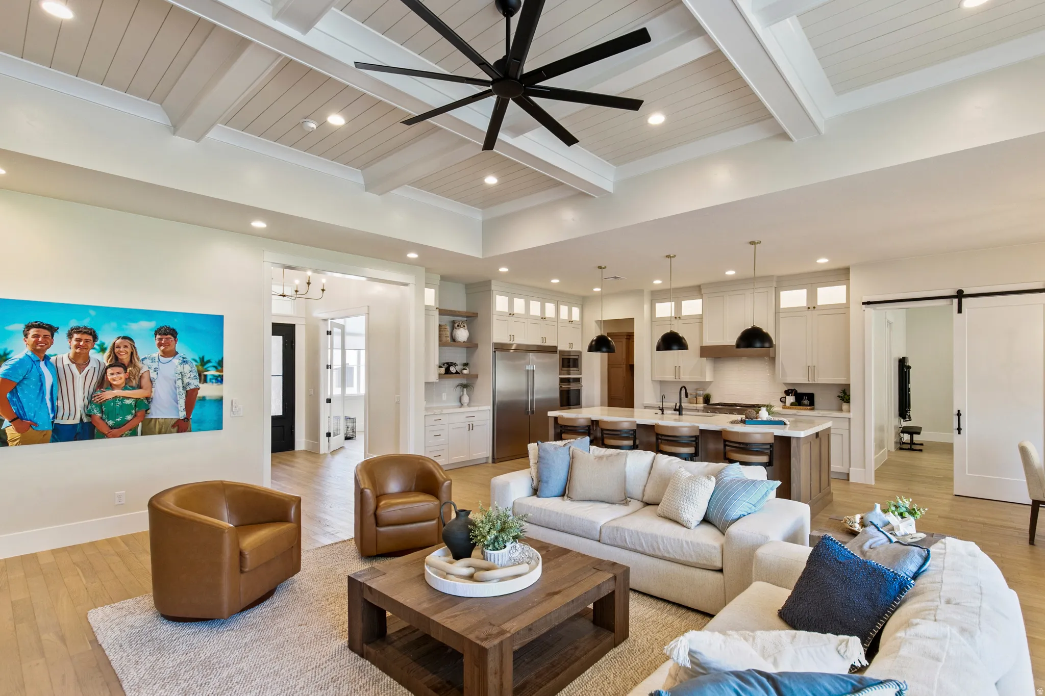 Open-concept interior featuring a coffered ceiling with a ceiling fan, light wood-finish flooring, and recessed lighting