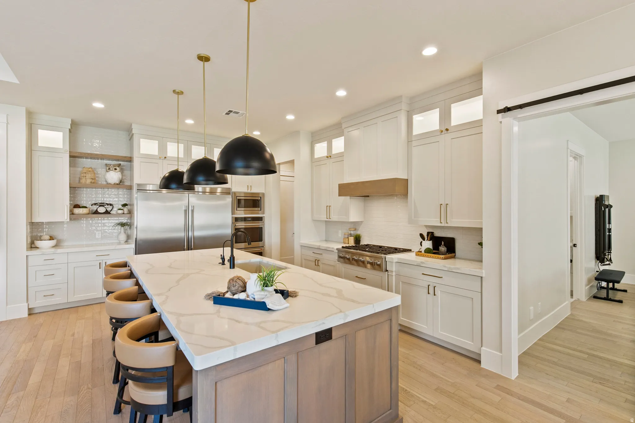 Gourmet kitchen featuring a substantial island with stone countertop, integrated sink, and seating for four