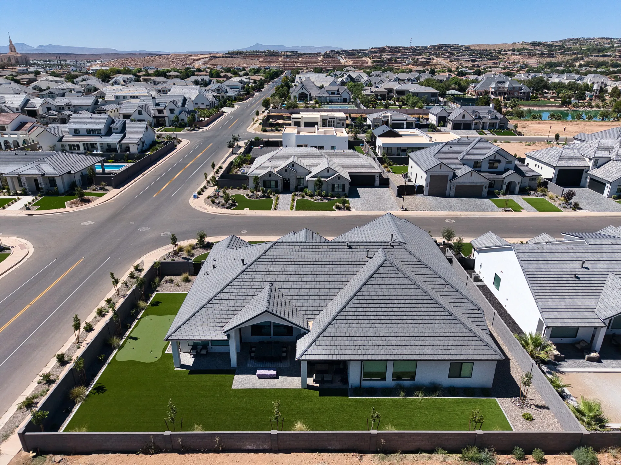 Contemporary residence featuring a grey tile roof and white exterior siding
