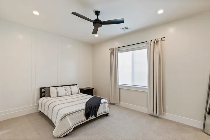 Interior room featuring a textured accent wall, recessed lighting, and a dark-toned ceiling fan