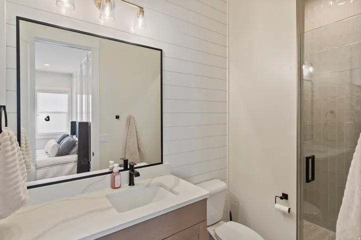 Bathroom featuring a vanity with an integrated sink, a quartz-finish countertop, and a black-framed mirror