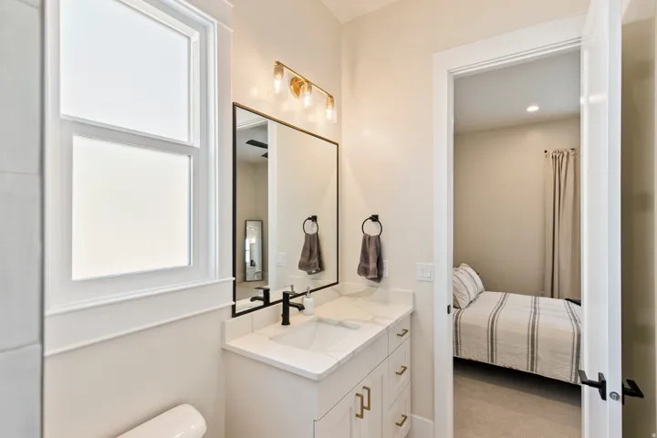 Bathroom vanity featuring a rectangular undermount sink, quartz countertop, and matte black faucet