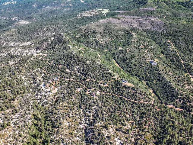 Expansive aerial view showcasing a mountainous landscape with dense tree coverage