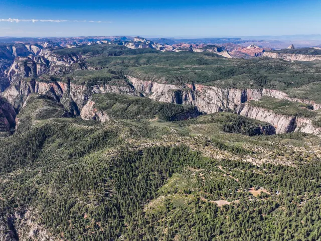 Expansive mountainous landscape with natural rock formations and abundant evergreen tree coverage