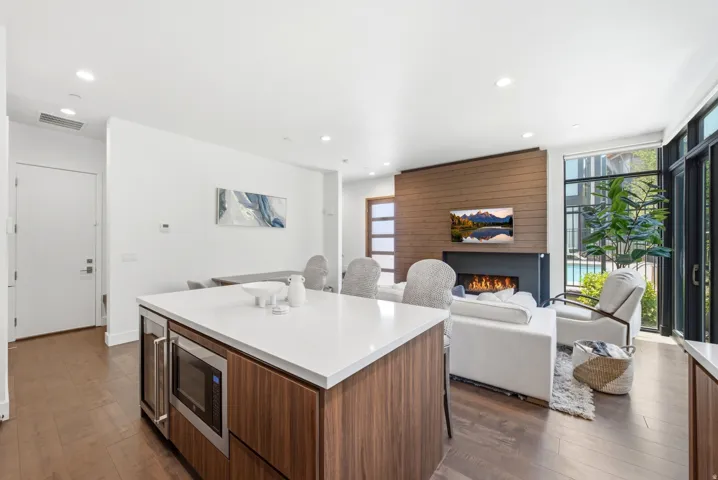 Kitchen island featuring a white countertop, built-in microwave, and integrated beverage cooler