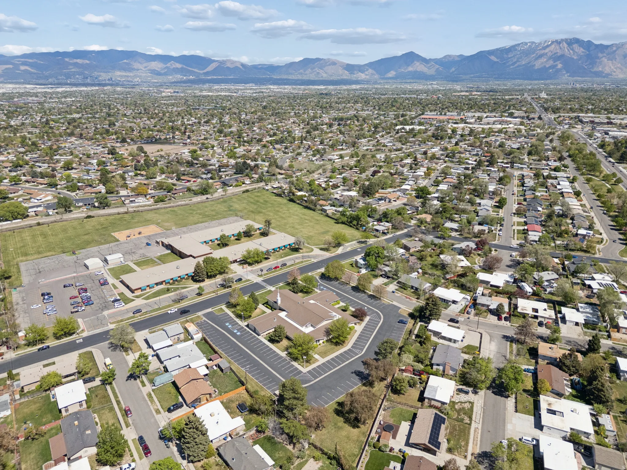 Expansive neighborhood setting featuring a mountainous backdrop, mature trees, and a mix of residential structures