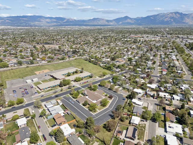 Expansive neighborhood setting featuring a mountainous backdrop, mature trees, and a mix of residential structures