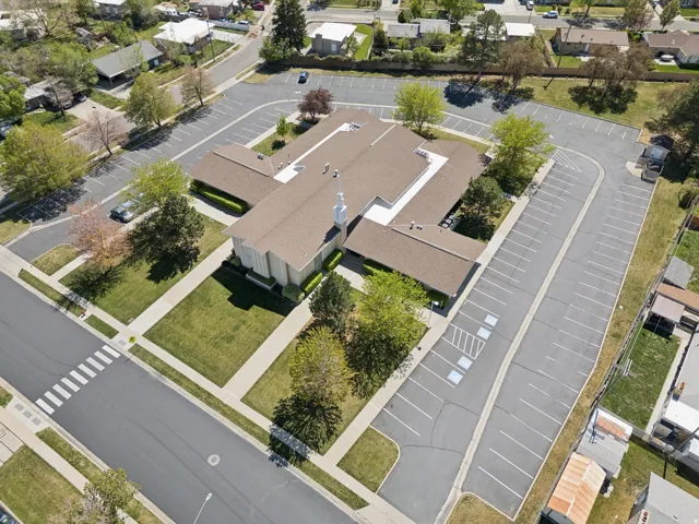 Expansive property featuring a large structure with a pitched roof, surrounded by extensive paved parking areas