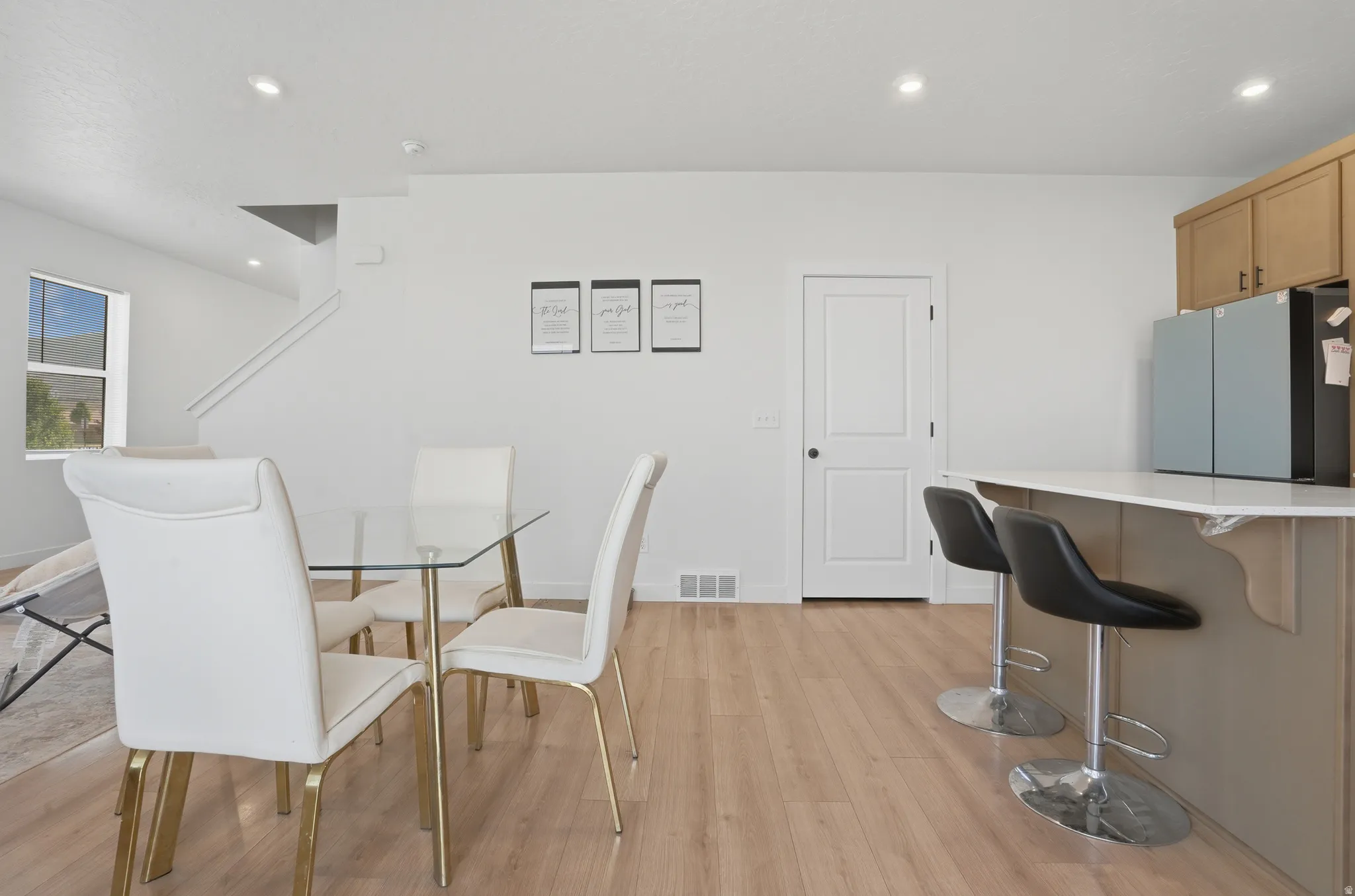 Open-concept living space featuring wood-finish flooring, recessed lighting, and a white color palette