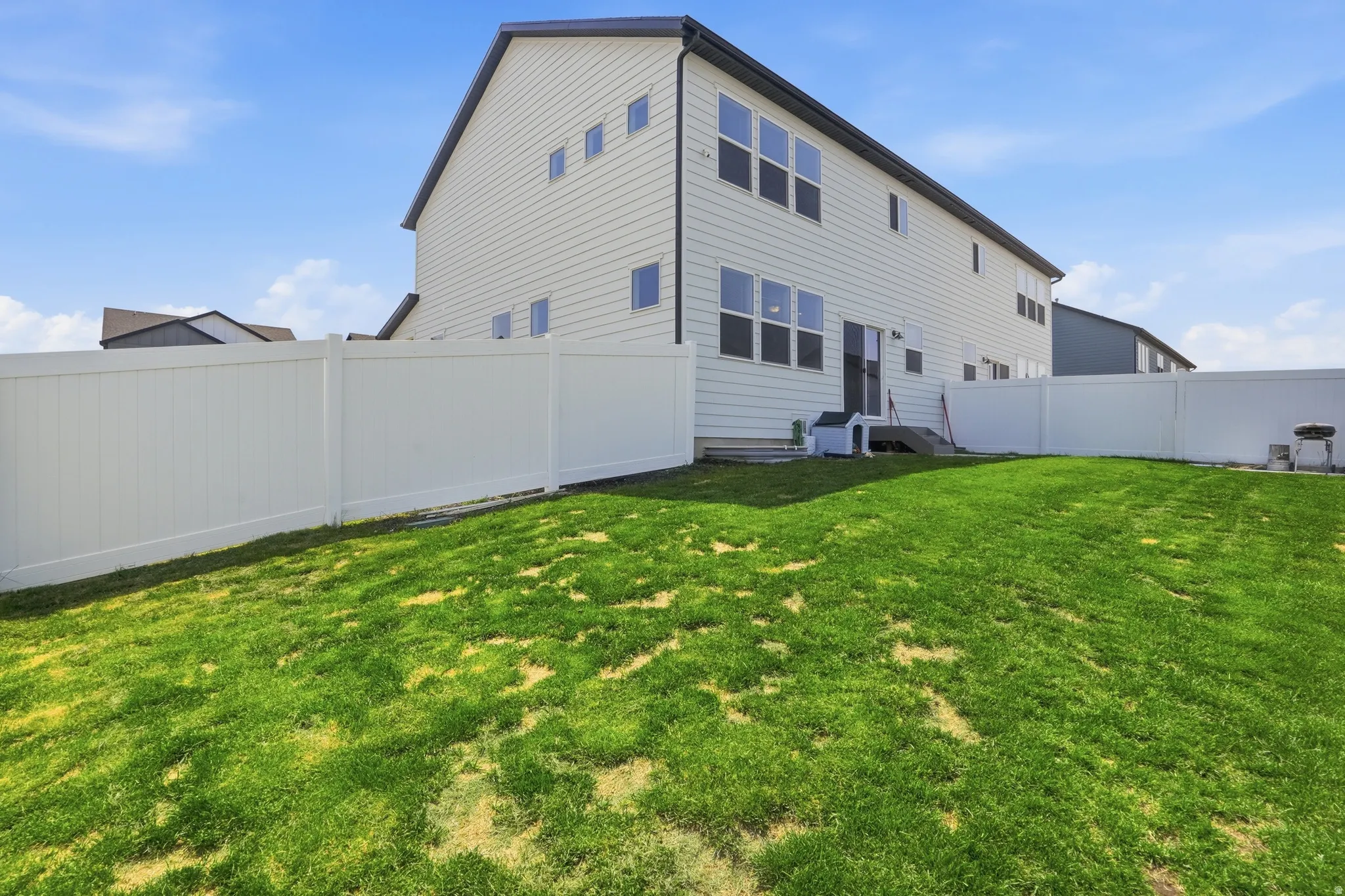 Expansive rear yard featuring a manicured lawn and complete privacy fencing