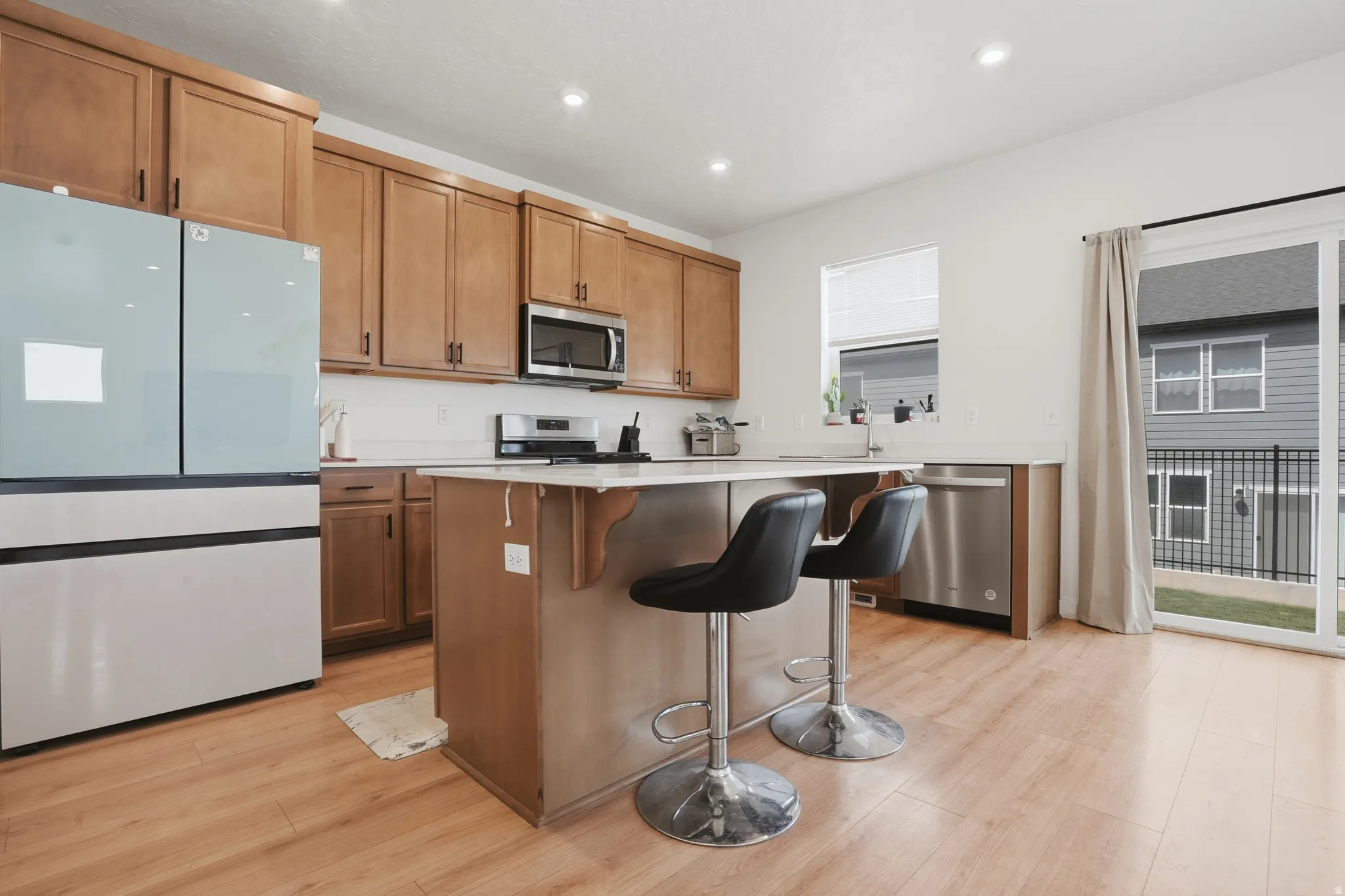 Open-concept kitchen featuring wood-finish flooring, recessed lighting, and a white subway tile backsplash