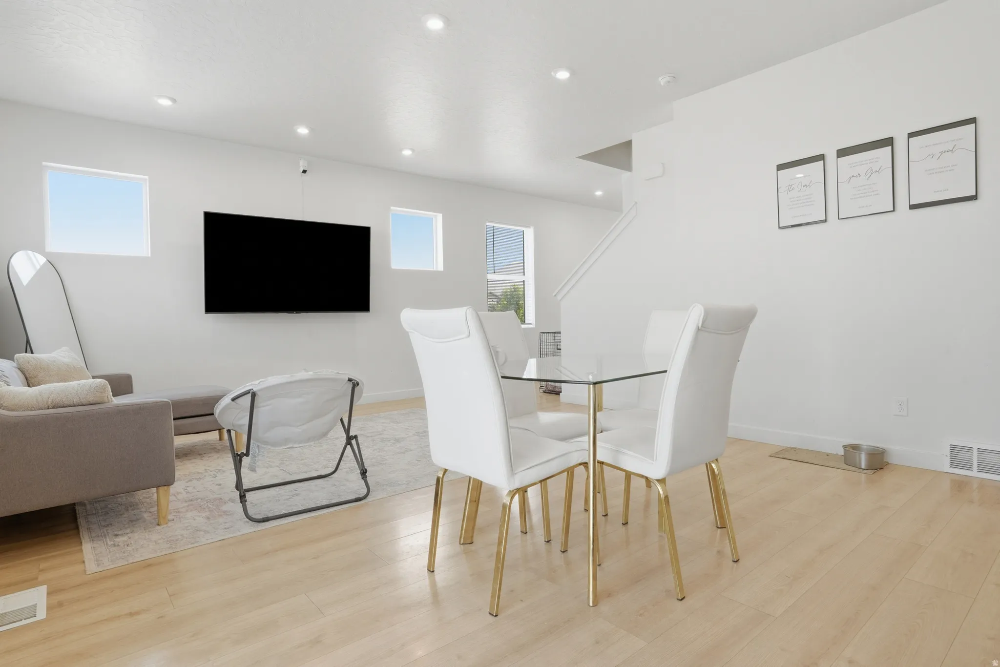 Bright open-concept living space featuring wood-finish flooring, recessed lighting, and crisp white walls