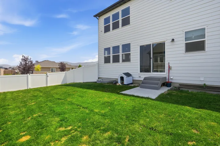 Expansive green lawn with a white vinyl fence encompassing the property