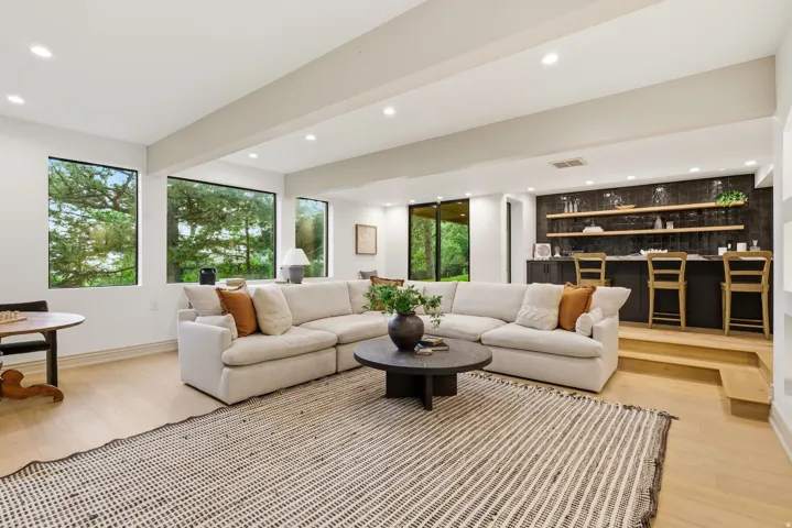 Spacious open-concept living area featuring light wood-finish flooring and recessed lighting