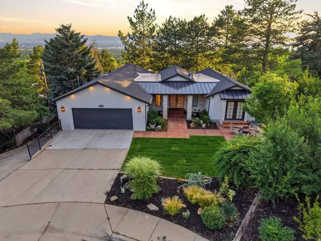 Modern dwelling featuring a dark metal roof, light-colored stucco exterior, and a two-car garage with a dark door