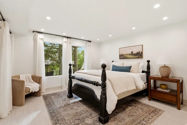 Spacious room featuring recessed lighting, multiple windows with white drapery, and neutral-toned wall-to-wall carpet